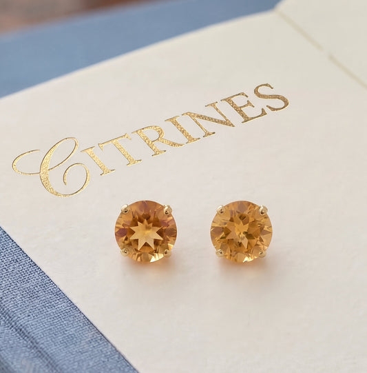Vue en macro de boucles d'oreilles puces en or jaune 18 carats serties de citrines jaunes rondes facettées