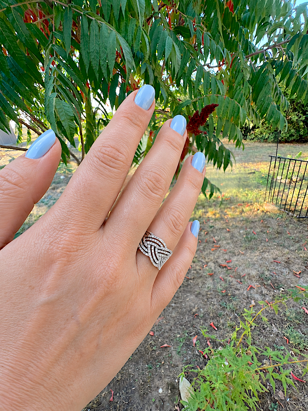 Bague de joaillerie diamants or blanc 18K portée au doigt, vue du dessus de la main