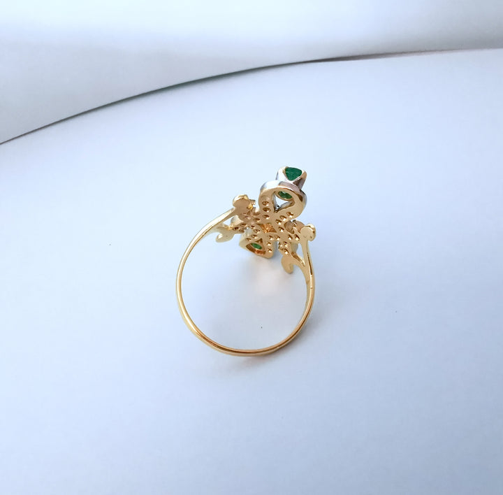 Vue de dessus de l'anneau d'une bague marquise en or deux tons serti d'émeraudes et de diamants