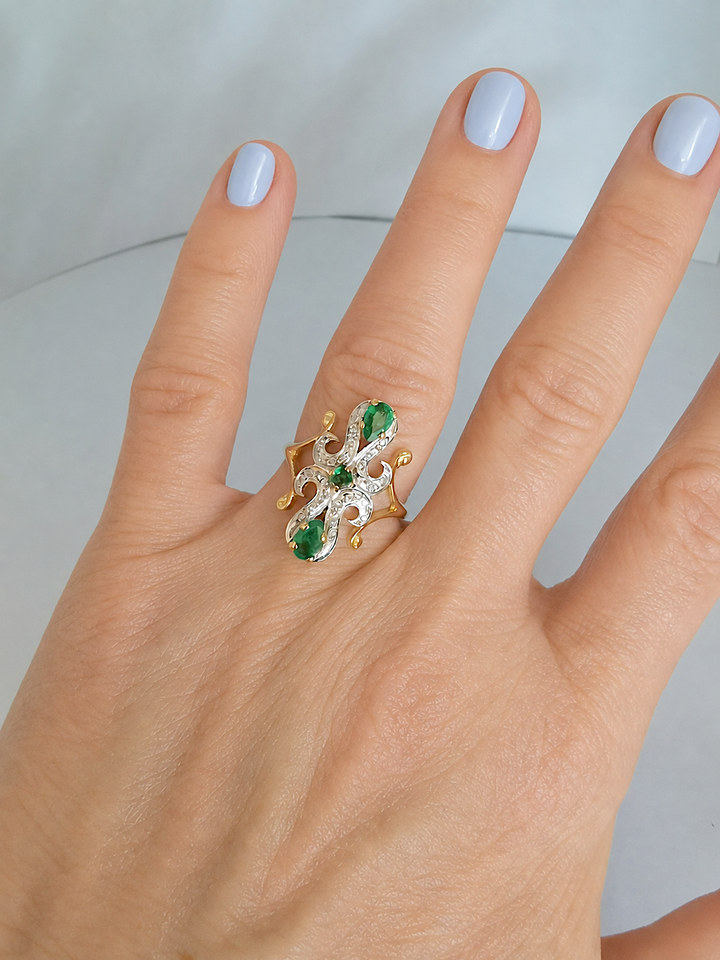 Bague marquise émeraudes et diamants portée à l'annulaire, joaillerie de seconde main