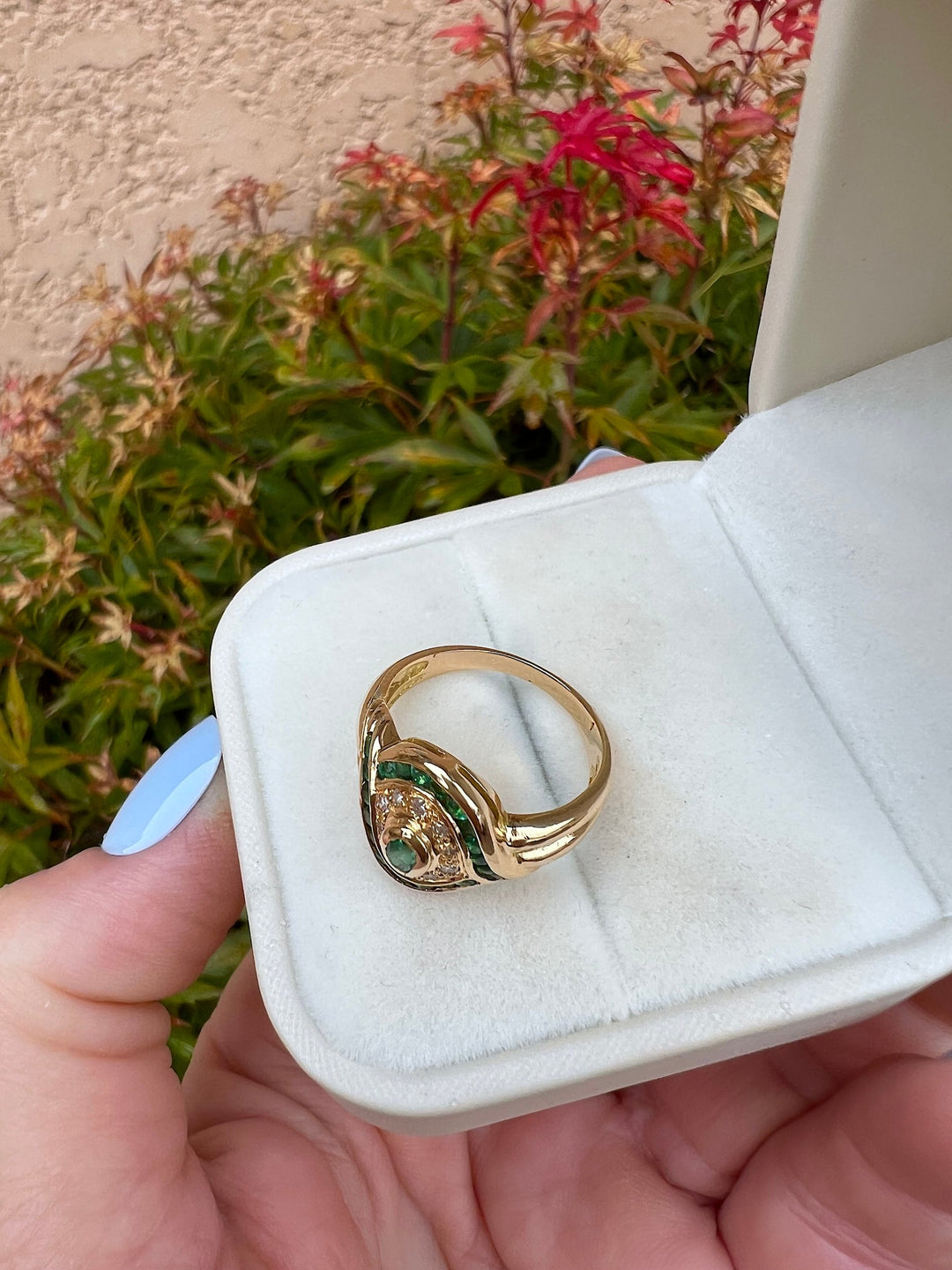Bague émeraude ovale et diamants en or jaune 18K en écrin blanc, vue de dessus montrant le jonc, joaillerie pour femme