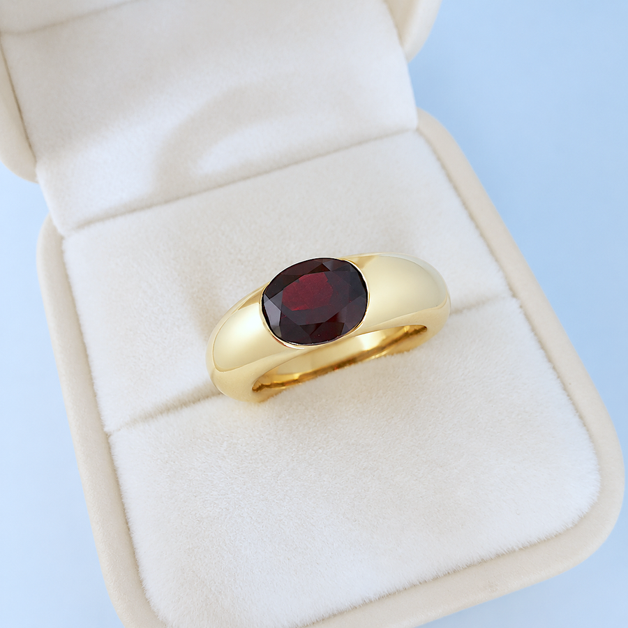 Bague jonc grenat or jaune 18K en écrin sur fond bleu