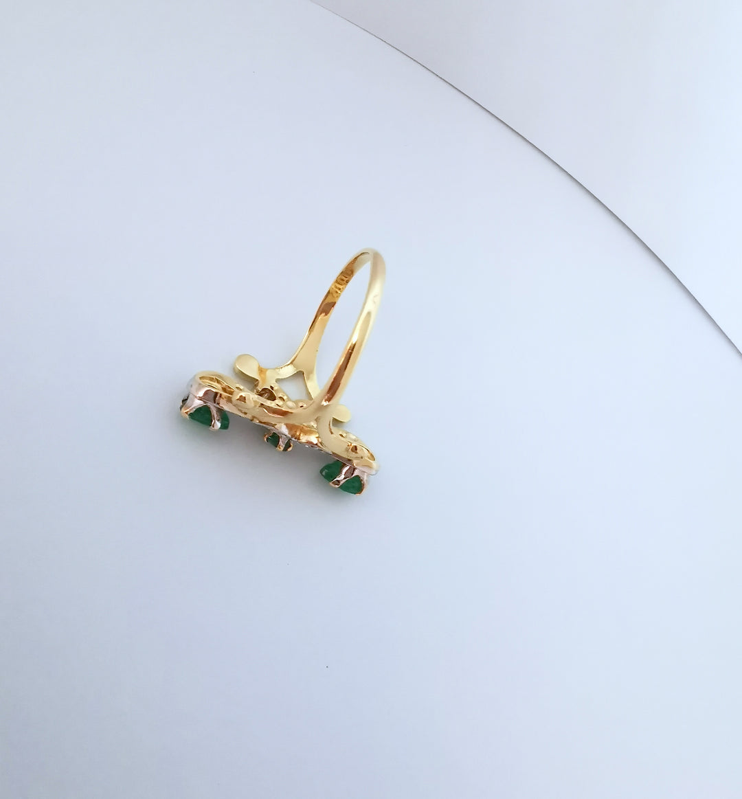 Profil d'une bague marquise or deux tons 18K montrant l'anneau et le sertissage des émeraudes