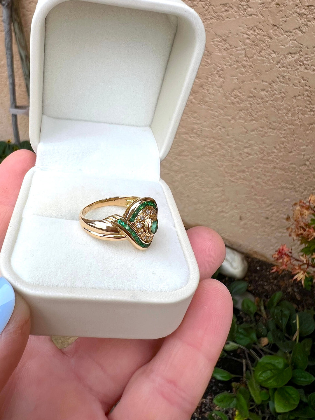 Monture en or jaune 18 carats d'une bague émeraudes et diamants, vue de côté en écrin blanc, joaillerie de seconde main