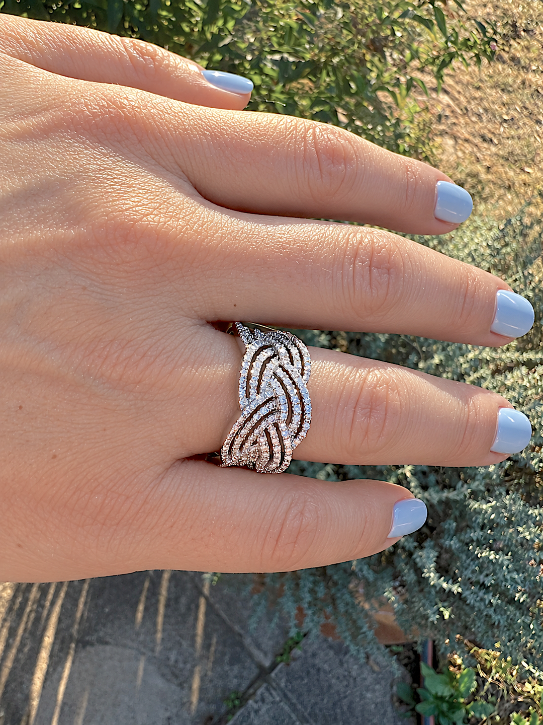 Bague de luxe pavée de diamants en or blanc, portée au doigt, vue rapprochée de la main