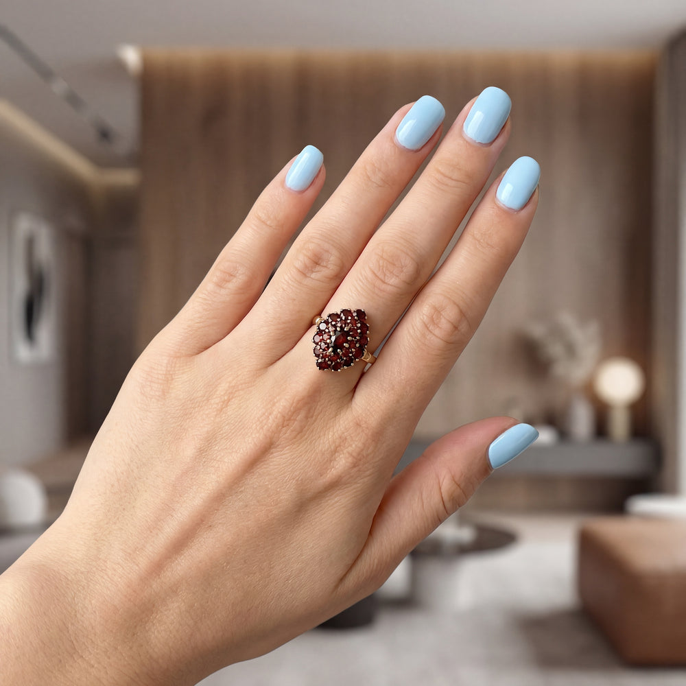 vue sur la main d'une femme bague grenats or 18 carats