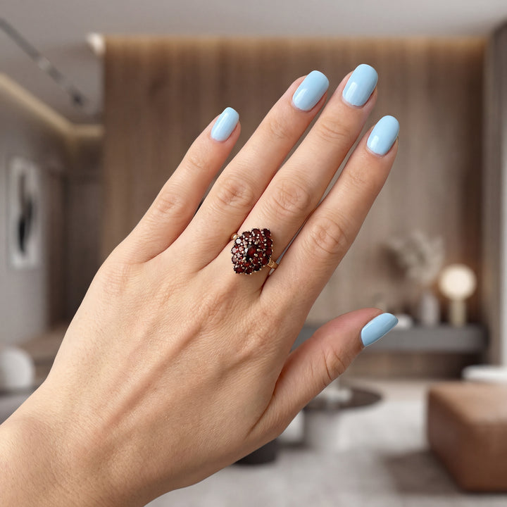 vue sur la main d'une femme bague grenats or 18 carats