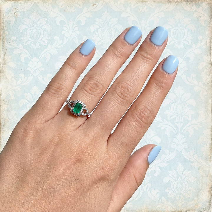 bague sur la main d'une femme bague maty diamants emeraude or blanc 18K