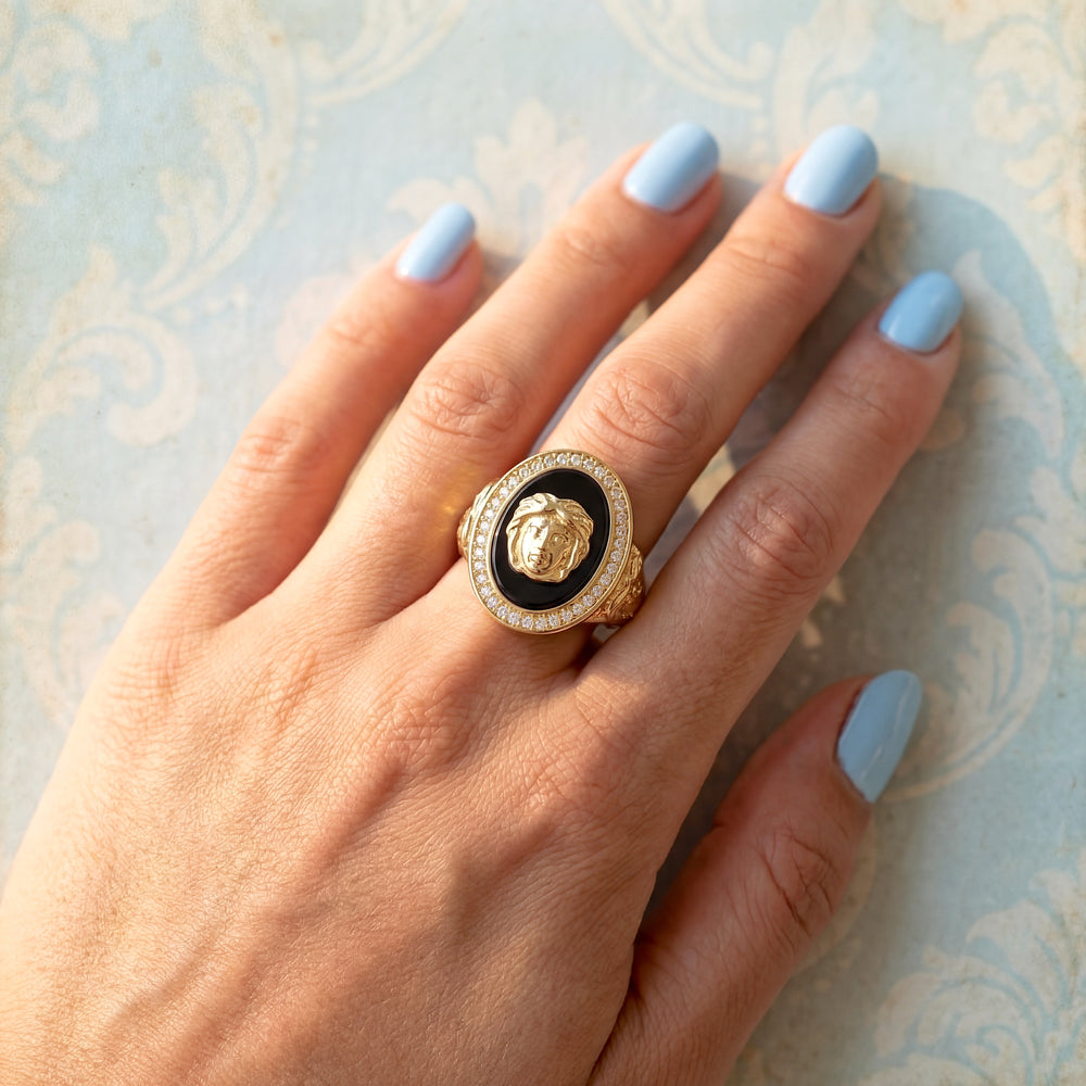 vue sur une main de femme bague onyx tete de gorgone or 18K