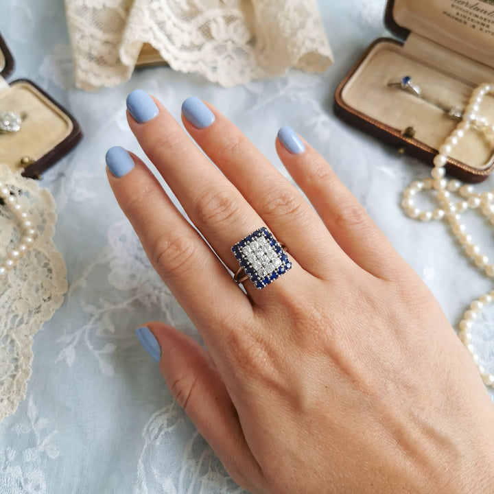 vue de la bague sur une main de femme bague vintage diamants saphir or gris 18 carats