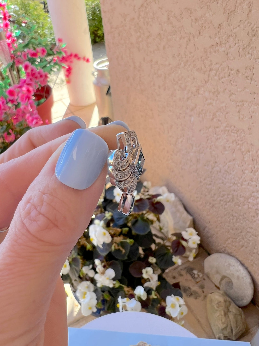Boucle d’oreille Art déco topazes bleues et diamants en or gris 18K, vue de profil tenue en main