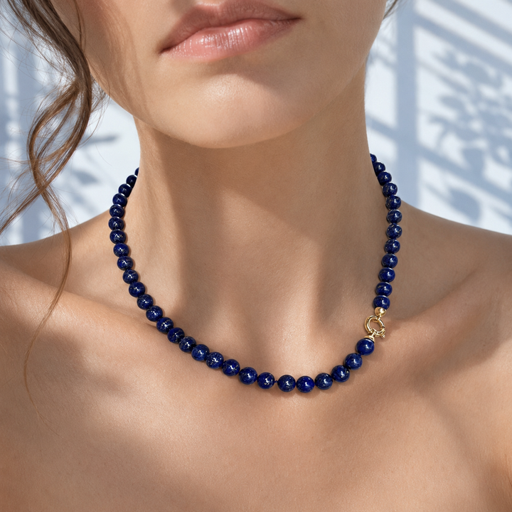 Femme portant un collier de perles en lapis-lazuli avec fermoir en or jaune 18 carats, bijou neuf