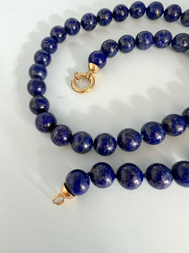 Femme portant un collier de perles en lapis-lazuli et or jaune 18 carats, bijou de joaillerie de luxe