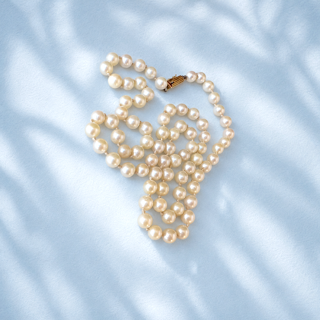 Collier perles de culture fermoir or jaune 18K, bijou de seconde main pour femme, vue d'ensemble sur fond bleu