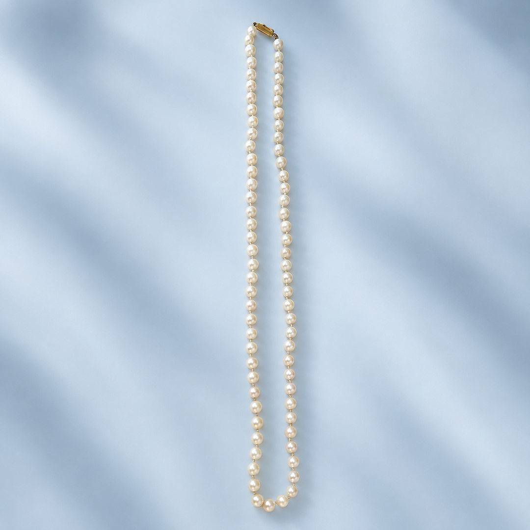 Collier de 75 perles de culture blanc crème présenté à plat sur toute sa longueur