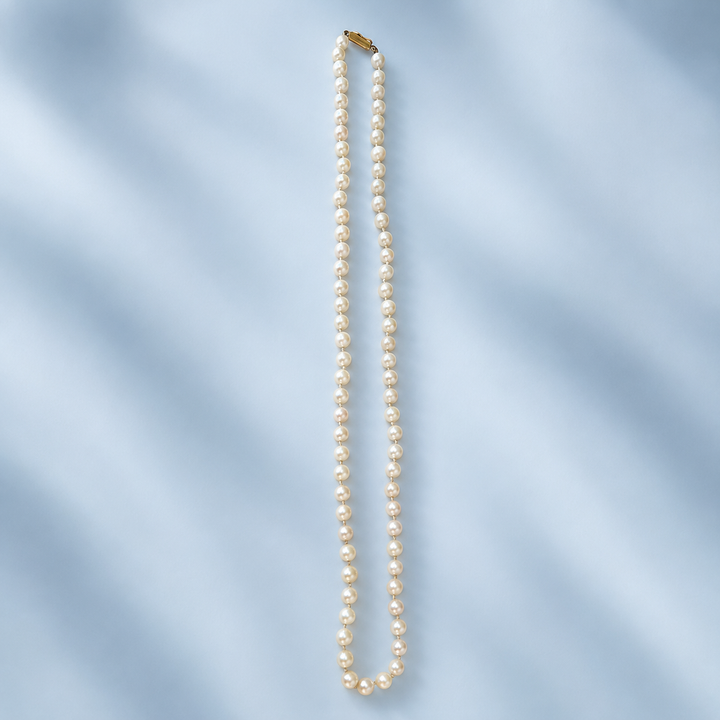 Collier de 75 perles de culture blanc crème présenté à plat sur toute sa longueur