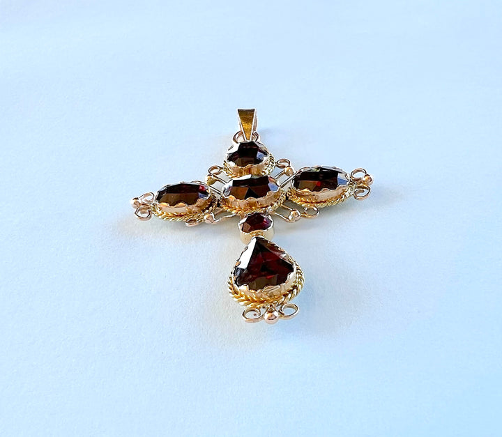 Croix grenats portée par une femme, bijou de seconde main