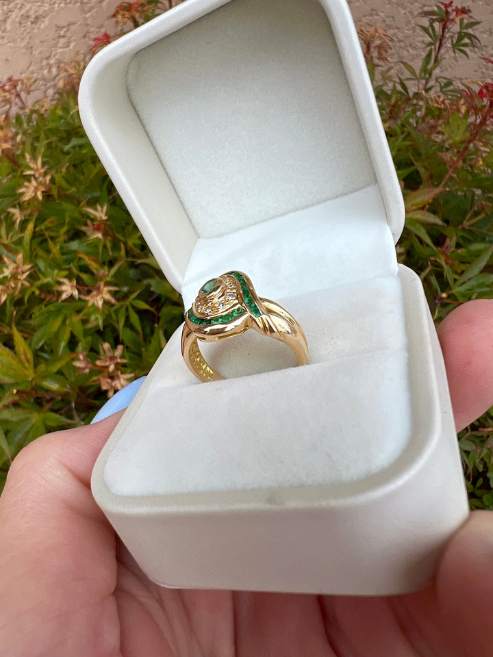 Bague émeraudes et diamants en or jaune 18K dans un écrin blanc ouvert, vue sur l'épaule de la monture, joaillerie de seconde main