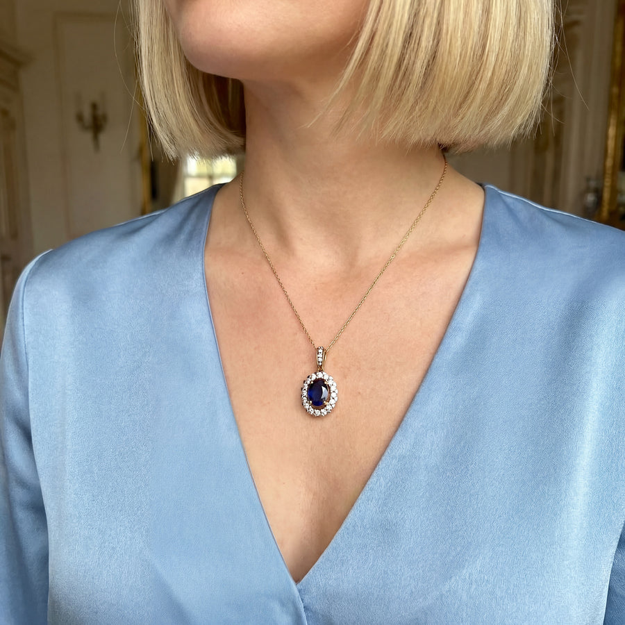 vue sur le cou d'une femme pendentif marguerite diamants saphir or 18K