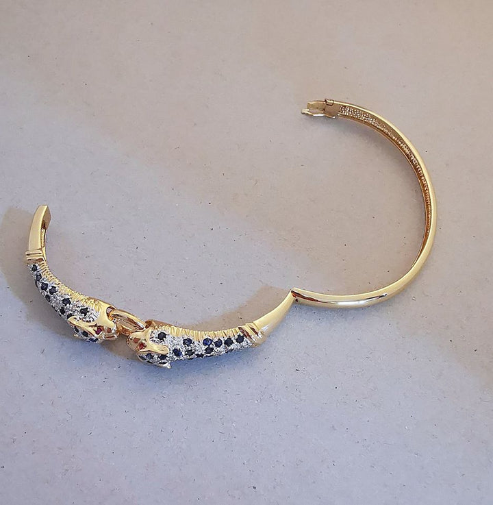 Bracelet ouvrant / 2 têtes de Panthère / Or 18 K / Diamants / Saphirs / 18 carats / 750