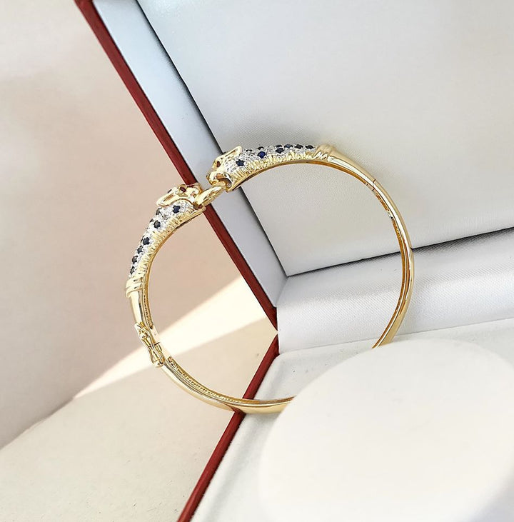 Bracelet ouvrant / 2 têtes de Panthère / Or 18 K / Diamants / Saphirs / 18 carats / 750