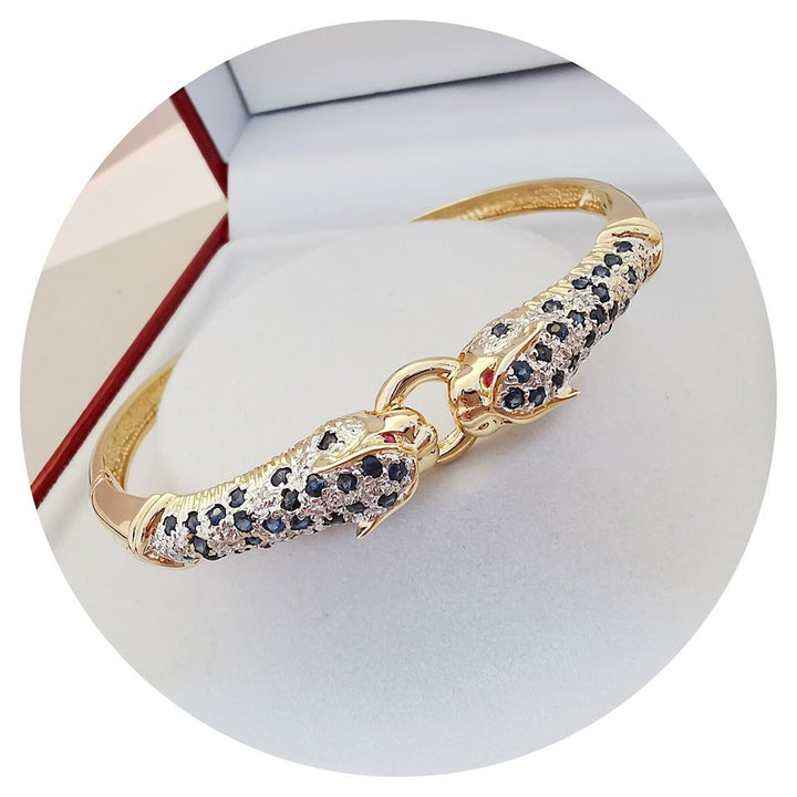 Bracelet ouvrant / 2 têtes de Panthère / Or 18 K / Diamants / Saphirs / 18 carats / 750