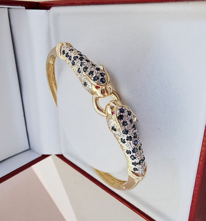 Bracelet ouvrant / 2 têtes de Panthère / Or 18 K / Diamants / Saphirs / 18 carats / 750